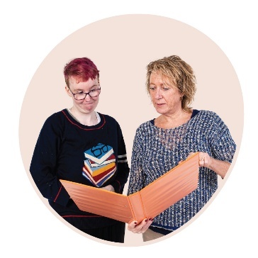 A person helping someone read from a folder.