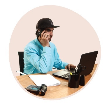 A person making a phone call as they use a laptop.